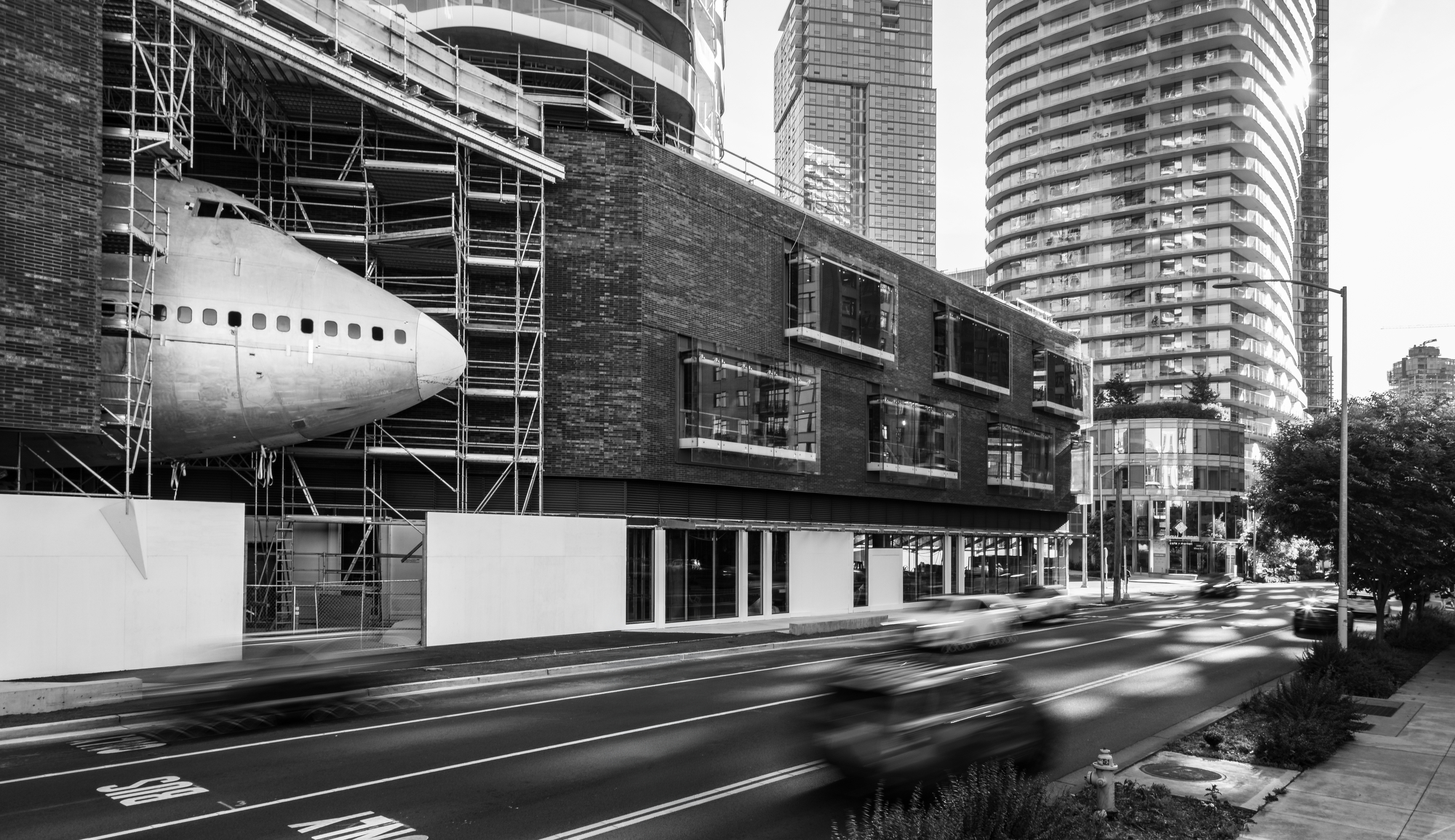 The nose of the Boeing 747 fuselage at AERO1200, with scaffolding, the building podium, and a Seattle street in view.