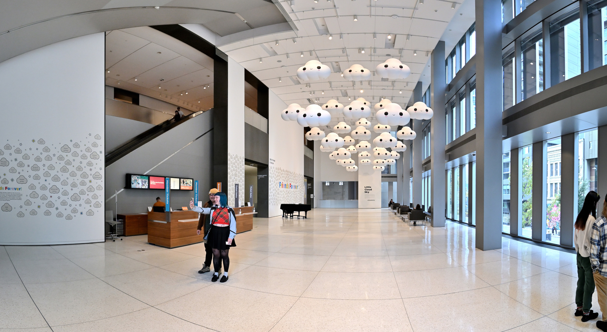 The Brotman Forum at the Seattle Art Museum in 2025, with the Little Cloud Sky installation of smiling cloud sculptures suspended overhead.