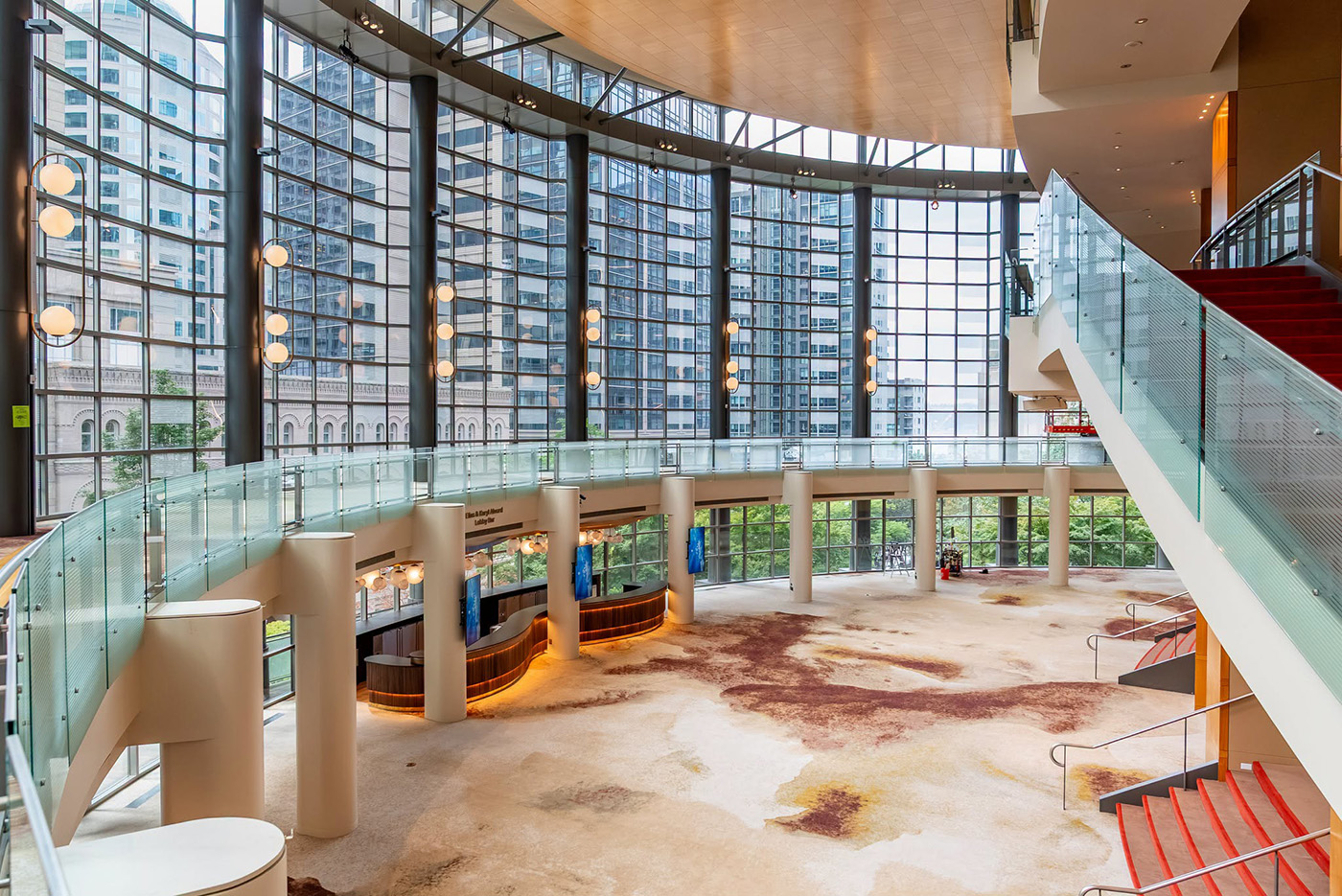 The refreshed grand lobby at Benaroya Hall, with its glass wall, new carpet, light fixtures, and central bar.